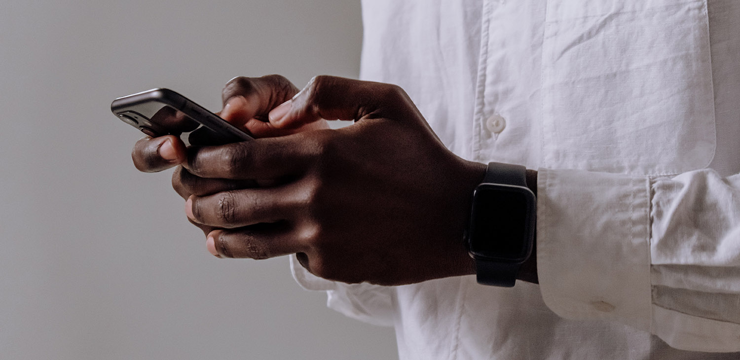 Closeup of African American Man holding phone, apparently texting