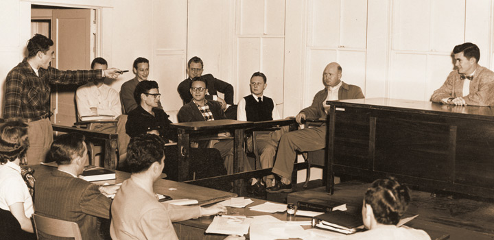 Historic, sepia toned photo of student pointing to witness while jury looks on. 