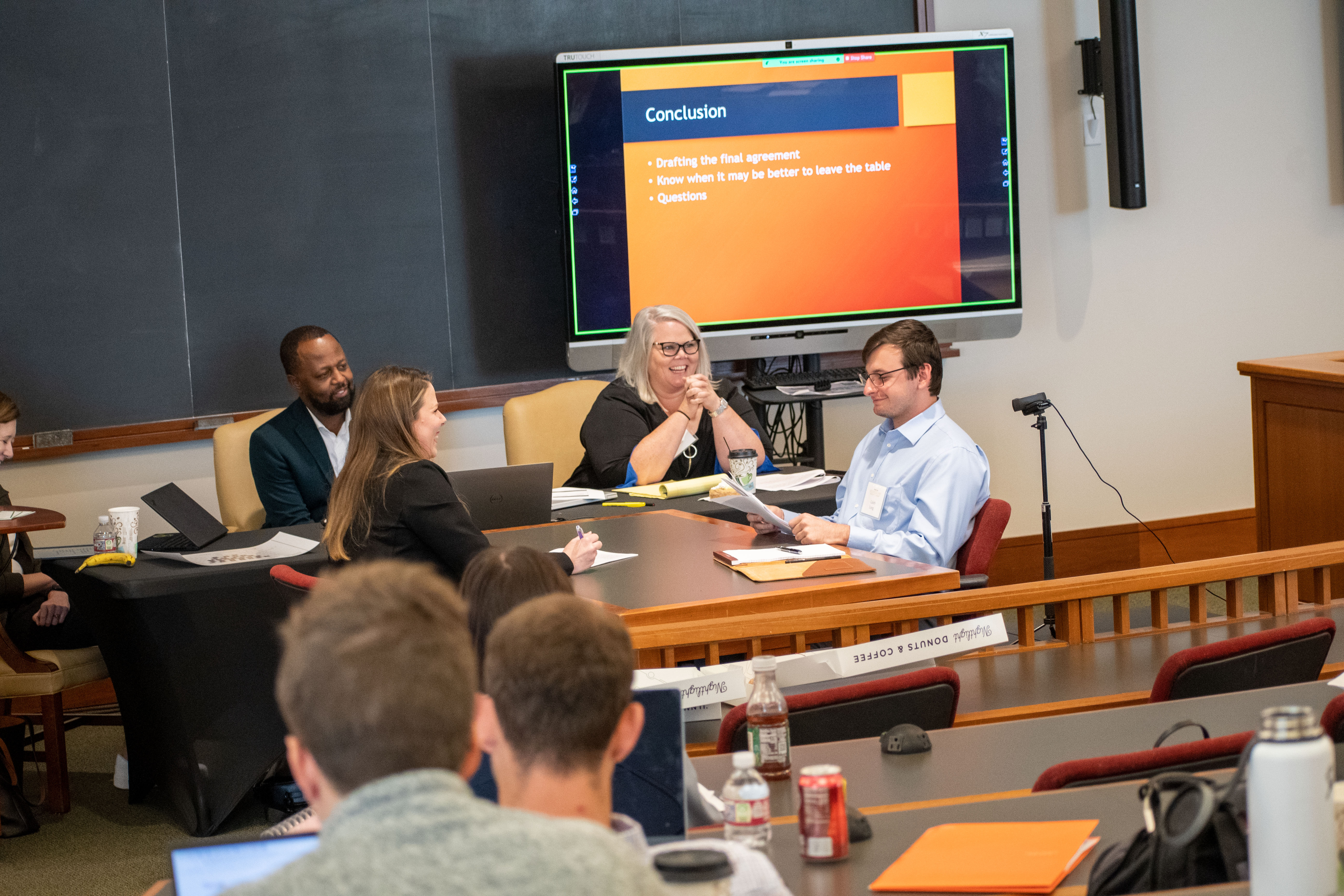 Steve Bolden, Shanna Nugent, and Professor Kayla Landeros watch as students Caleb Long and Christine Barfield participate in a mock negotiation