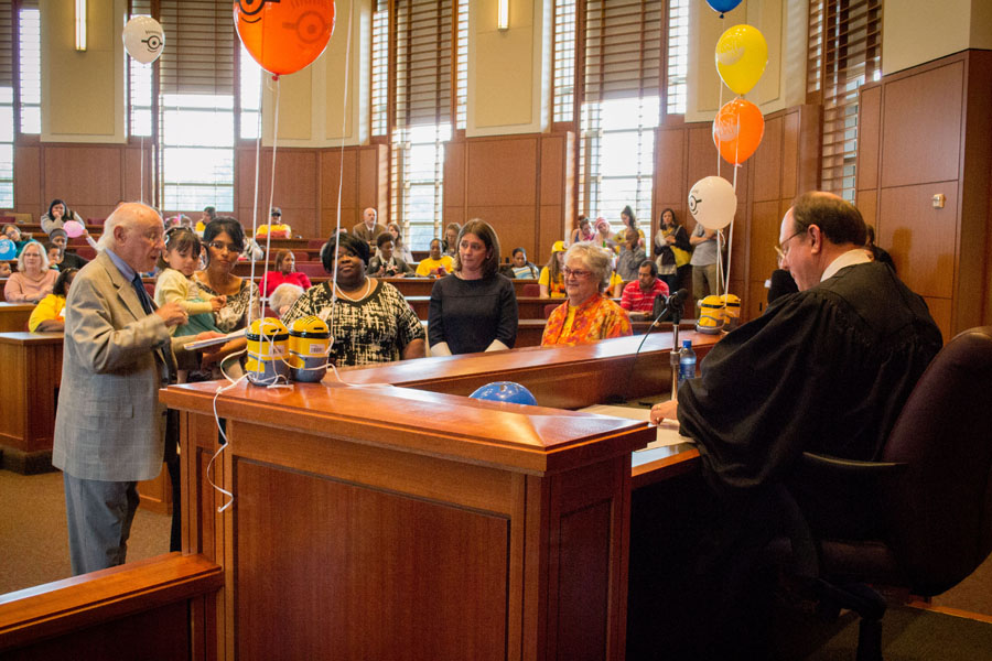 Judge Coley sits behind colorfully decorated bench in a balloon-filled courtroom at Baylor Law