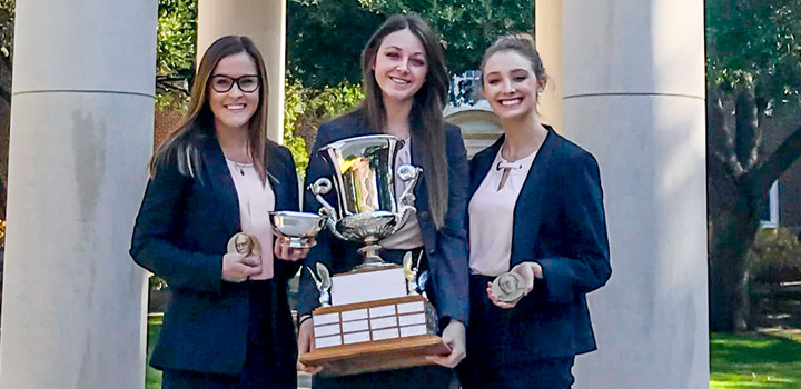 All-female mock trial team holding large trophy