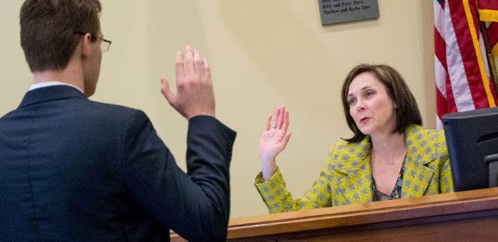 Student raising right hand, swearing before a judge in Practice Court
