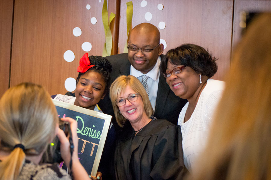 A family poses for a photo with the judge during adoption day 2016