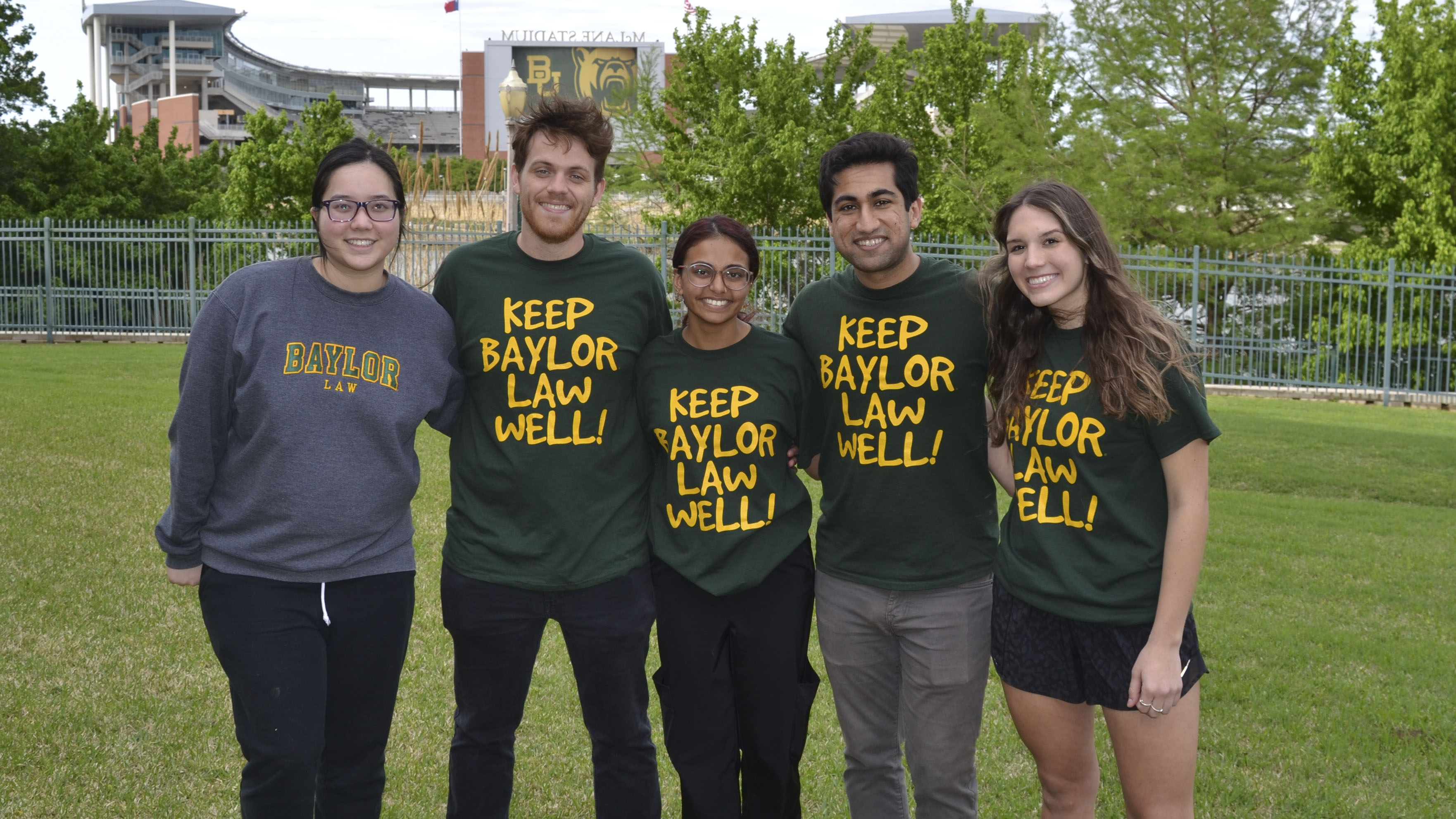 Students from the Student Wellness Organization post on the back lawn of Baylor Law, all are wearing 'Keep Baylor Law Well' T-shirts