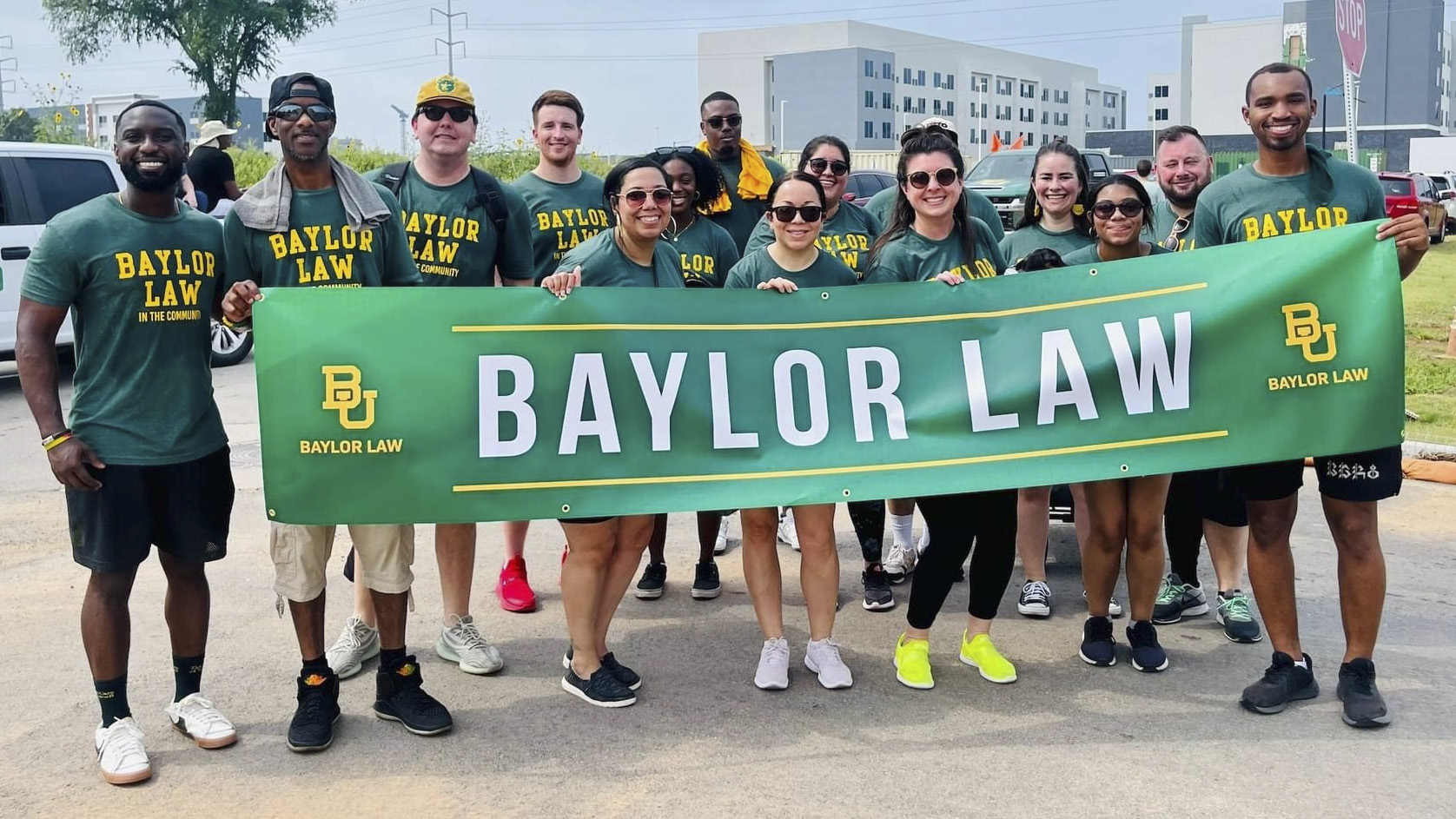Students pose with Baylor Law banner at the City of Waco's Juneteenth Parade in 2023