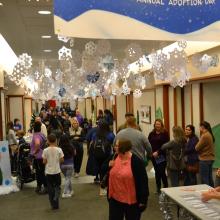 Crowds of families in the hallways at Baylor Law. Hundreds of paper snowflakes hang from the ceiling.