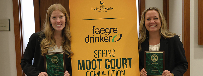 Winners of the 2026 Faegre Drinker Moot Court Competition, Lillian Hawkins and Mackenzie Gillette, pose with their awards after the competition