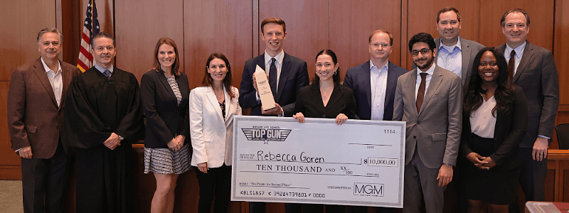 Top Gun XVII presiding judge, final round Judges, Dean Jeremy Counseller, pose with winner holding large foamboard check for $10,000.00